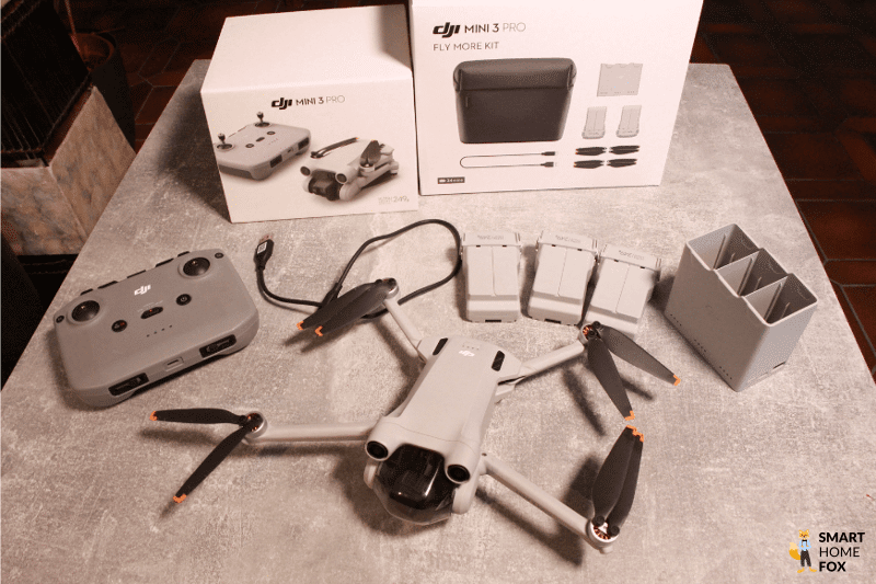 Das DJI Fly More Kit und die DJI Mini 3 Pro liegen auf einem Tisch.